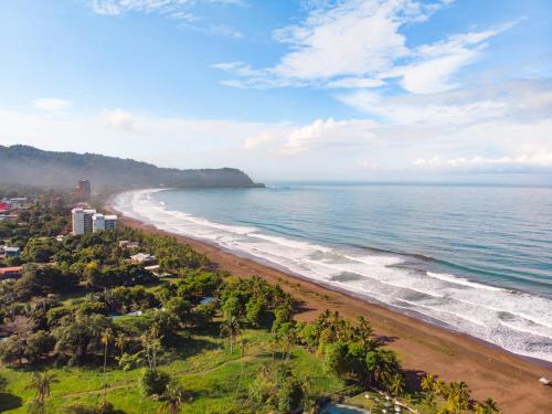una vista aerea di una spiaggia con alberi e l'oceano di Hostel de Haan a Jacó
