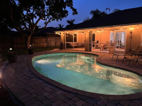 a swimming pool in a backyard at night at Southern Charm meets sunny FL fun! Home with pool and central to everything. in Cape Coral