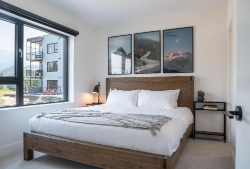 a bedroom with a large bed and windows at Glades and Greens by Revelstoke Vacations in Revelstoke