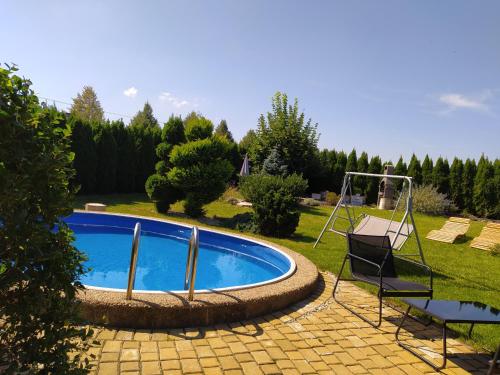 una piscina en un patio con un columpio en Vila Callum RELAX & WELLNESS, en Ostrava
