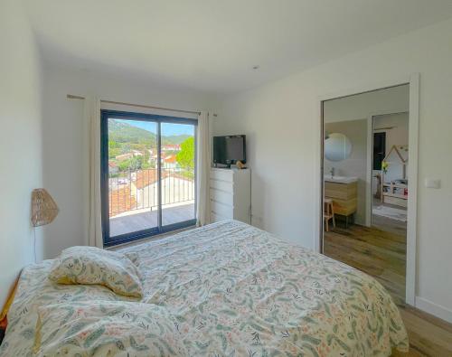 a bedroom with a bed and a large window at La Villa Bégonia in La Penne-sur-Huveaune