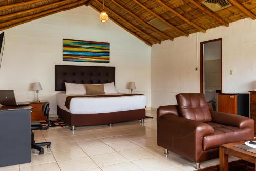 a bedroom with a bed and a desk and a chair at Qala Hotels & Resorts in Chincha Alta