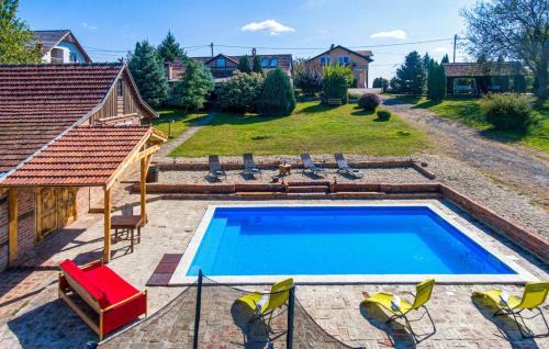 einen Pool in einem Garten mit Stühlen und einem Haus in der Unterkunft Kuća za najam - IMANJE LUNA BAZEN JACUZZI in Sveti Ivan Žabno