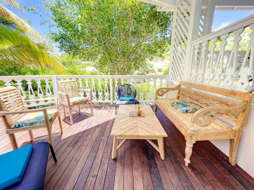 una terrazza con sedie, tavolo e panca di Villa Bulle clothing optional around the prival pool a Orient Bay