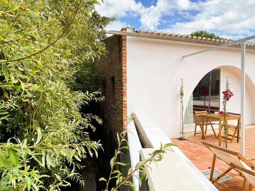 a patio of a house with a table and chairs at Casa do Rio in Leiria