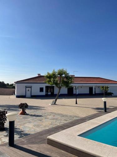 a building with a swimming pool in front of a building at Alojamento do Monte in Estremoz