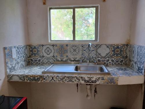 a kitchen counter with a sink and a window at Apts. LOSSANTOS in Matamoros