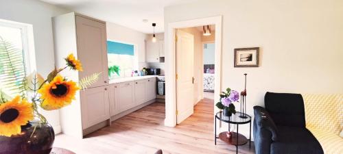 a kitchen and a living room with a vase of sunflowers at Butterfly Guesthouse - Entire Home within 5km of Galway City in Galway