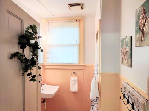 łazienka z umywalką, toaletą i oknem w obiekcie #06 - Lakeview Two Bedroom Cottage-Pet Friendly w mieście Hot Springs