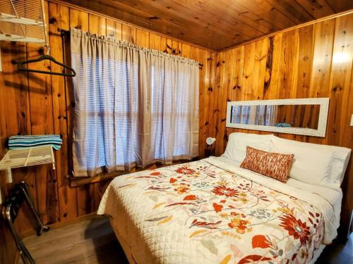 a bedroom with a bed in a wooden cabin at #07 - Lakeview One Bedroom Cottage-Pet Friendly in Hot Springs