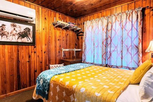 ein Schlafzimmer mit einem Bett in einem Zimmer mit Holzwänden in der Unterkunft #08 - One Bedroom Lakeview Cottage-Pet Friendly in Hot Springs