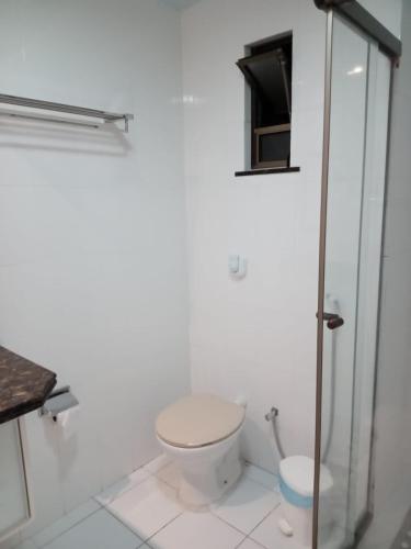 a white bathroom with a toilet and a shower at Loft na Prainha - Arraial do Cabo in Arraial do Cabo