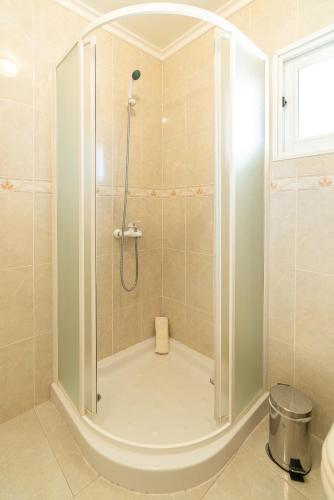 a bathroom with a shower with a glass door at Noite´s House - Prazeres in Prazeres