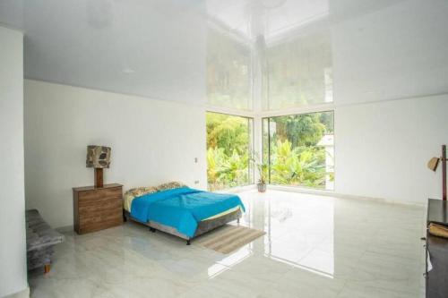 a bedroom with a bed and a large window at Espectacular Quinta privada in Viotá