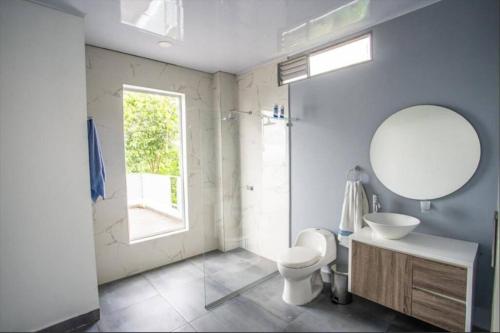 a bathroom with a toilet and a sink and a mirror at Espectacular Quinta privada in Viotá