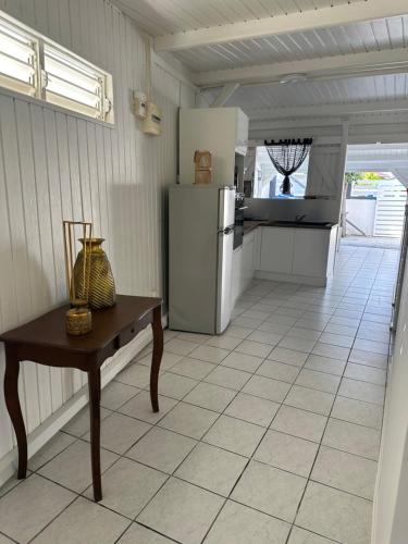 a kitchen with a refrigerator and a table in it at L'améthyste in Saint-François