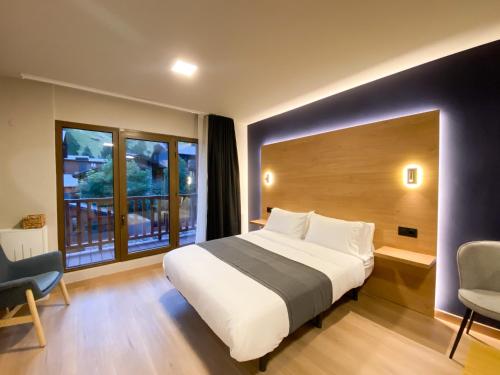 een slaapkamer met een groot bed en een groot raam bij Modern Blue Studio En Valle De Incles - Parking Gratis in Canillo