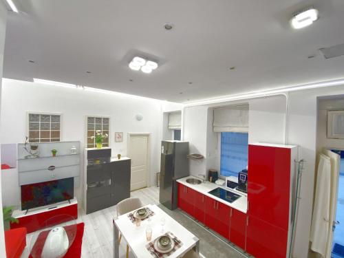 een keuken met rode en witte kasten en een tafel bij Yes, yes! lovely apartment good amenities Budapest center in Boedapest