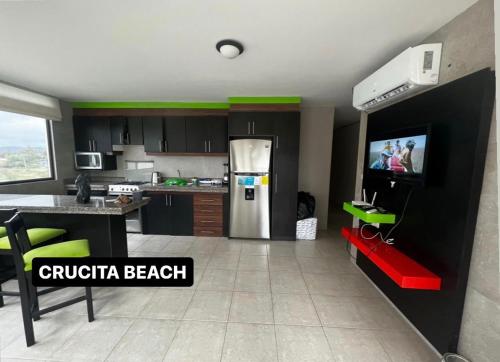 een keuken met een koelkast en een tv. bij CRUCITA BEACH KP in Crucita