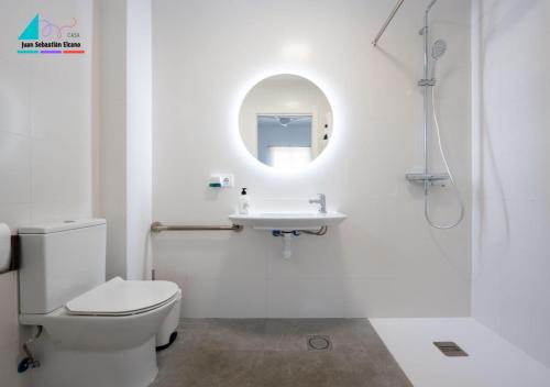 a white bathroom with a toilet and a sink at Casa Juan Sebastian Elcano in Gelves
