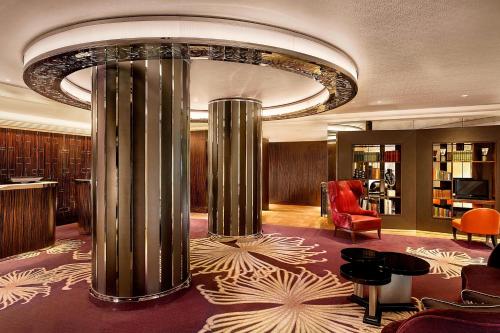 eine Hotellobby mit einer großen Säule in der Mitte in der Unterkunft Sheraton Grand London Park Lane in London