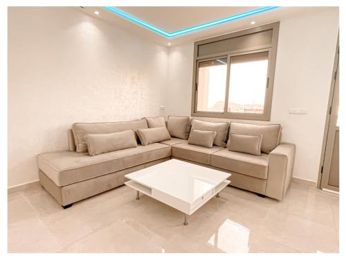 a living room with a couch and a coffee table at Appartement de luxe Al hoceima in Al Hoceïma