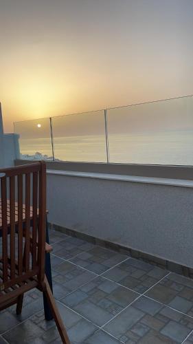 a person sitting on a bench on a balcony at Appartement de luxe Al hoceima in Al Hoceïma