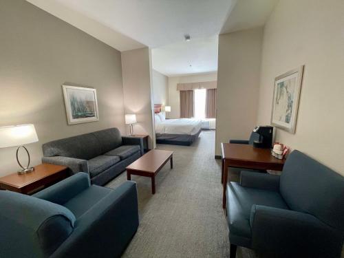 a living room with couches and a bed in a hotel room at Best Western Plus Executive Hotel & Suites in Sulphur