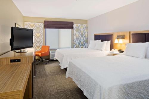 a hotel room with two beds and a flat screen tv at Hampton Inn & Suites by Hilton Walla Walla in Walla Walla