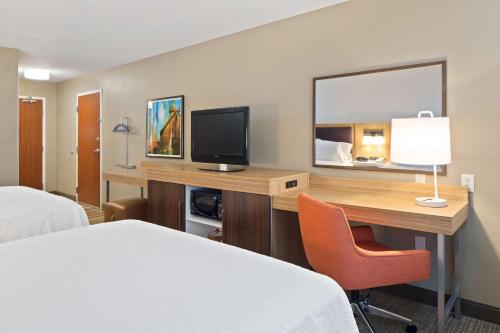 a hotel room with a desk with a television and a bed at Hampton Inn & Suites by Hilton Walla Walla in Walla Walla