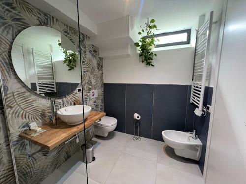 a bathroom with a sink and a toilet and a mirror at La Perla in Monza