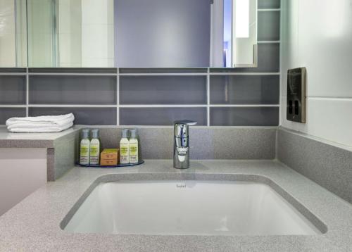 La salle de bains est pourvue d'un lavabo et d'un miroir. dans l'établissement Hilton Garden Inn Dublin City Centre, à Dublin