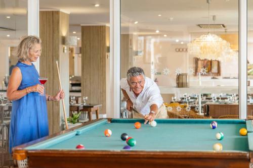 a man and woman standing next to a pool table at Florasol Residence Hotel - Dorisol hotels in Funchal