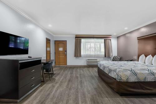 Motel 6 Carlsbad, Ca- North في كارلسباد: غرفة فندقية بسرير وتلفزيون بشاشة مسطحة