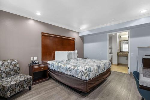 a hotel room with a bed and a chair at Motel 6 Carlsbad, Ca- North in Carlsbad