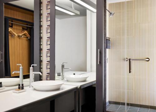 a bathroom with three sinks and a shower at Aloft Leawood-Overland Park in Overland Park