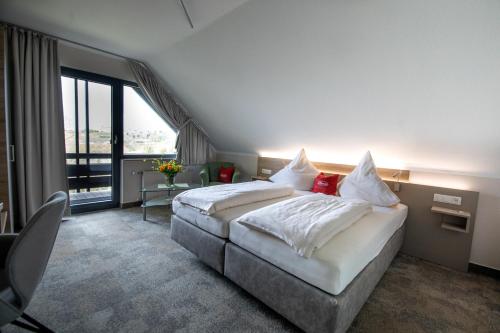a hotel room with a bed and a large window at Landgasthof Zur Erholung in Breitscheid