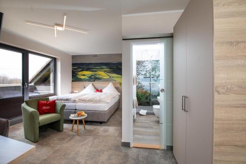 ein Wohnzimmer mit einem Bett und einem Sofa in der Unterkunft Landgasthof Zur Erholung in Breitscheid