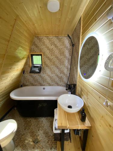 a bathroom with a tub and a toilet and a sink at Cozy cabin in Tbilisi City