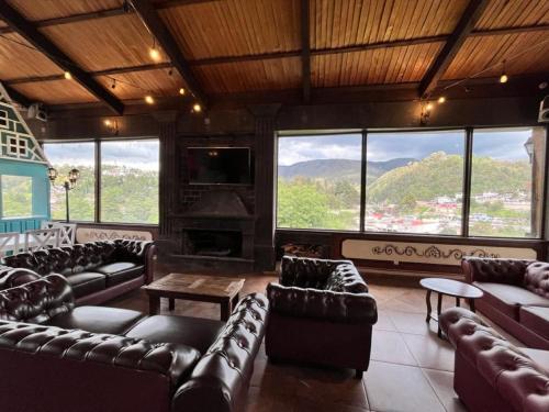 a living room with leather couches and a fireplace at Villa Claus Inn in Tlalpujahua de Rayón