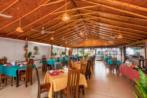 a dining room with tables and chairs and wooden ceilings at Qala Hotels & Resorts in Chincha Alta