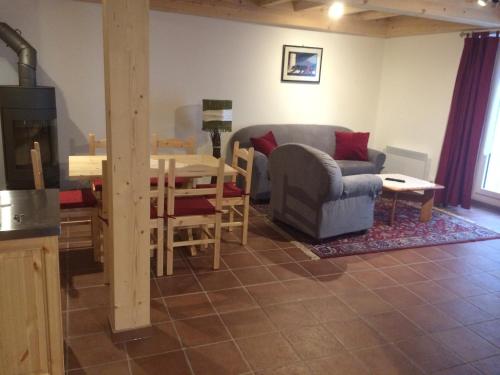 sala de estar con mesa, silla y sofá en Osteria Del Centro, en Brusio