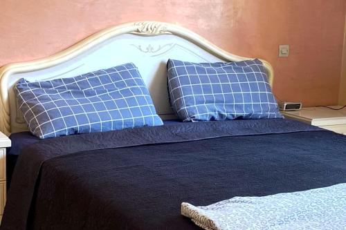 a bed with blue and white pillows on it at Temara in Temara