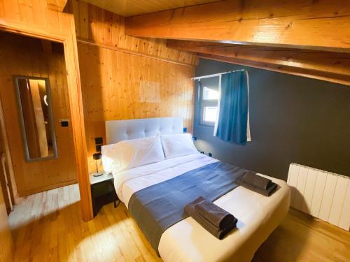 1 dormitorio con 1 cama grande y pared azul en Lujoso Ático Dúplex En Valle De Incles - Parking Gratis, en Canillo