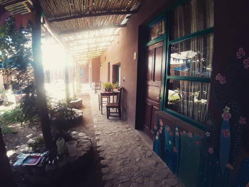 Humahuaca Hostel في هوماهواكا: مدخل منزل مع الشمس مشرق من خلال النافذة