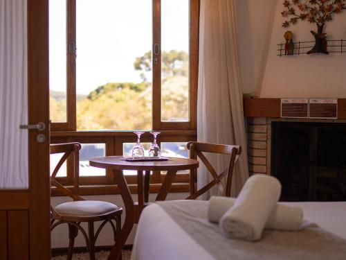 a room with a table and chairs and a fireplace at Pousada Suiça Mineira Centro in Monte Verde