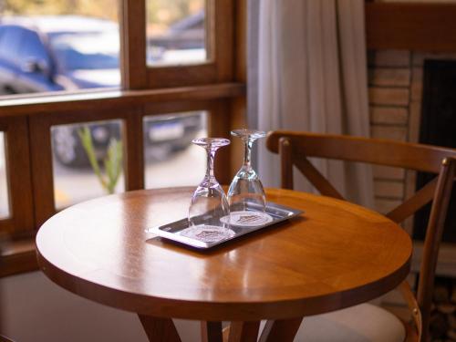 two glass bottles on a tray on a table at Pousada Suiça Mineira Centro in Monte Verde