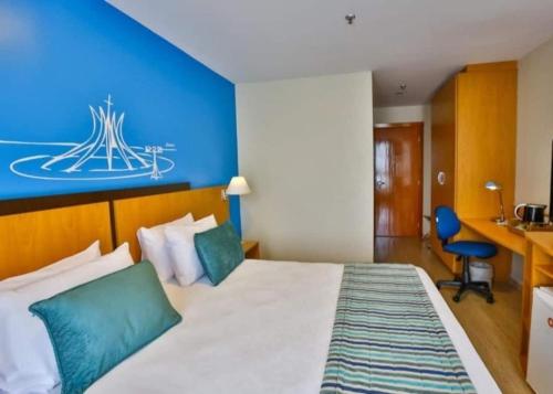 a hotel room with a bed and a blue wall at Lindo Flat 10° andar aconchegante em Brasilia in Brasilia