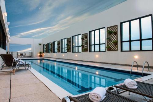 a large swimming pool with chairs in a building at Lindo Flat 10° andar aconchegante em Brasilia in Brasilia