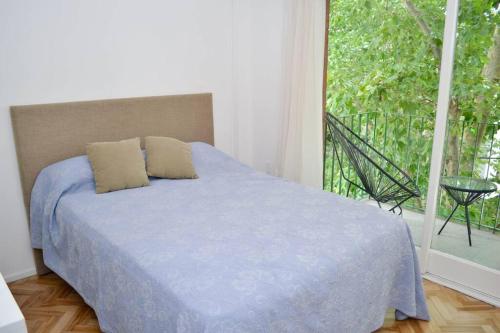 ein Schlafzimmer mit einem Bett und einem großen Fenster in der Unterkunft Chacabuco 255 by depptö in San Isidro